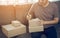 Young asian man business owner hands writing address on cardboard box at workplace or home office