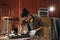 Young Asian man Carpenter uses a tape measure to measure chair on the workbench in woodcraft carpentry workshop.