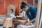 Young Asian man Carpenter uses a tape measure to measure wood on the workbench in woodcraft carpentry workshop.