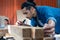 Young Asian man Carpenter uses a tape measure to measure wood on the workbench in woodcraft carpentry workshop.