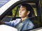 Young asian man driving a car