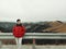 Young Asian Man Enjoying in the Wind and Mist on Mountain Top with Beautiful Landscape in Background