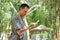 Young asian man looks at the screen of mobile phone. Attractive young asian man looks at the mobile screen at the park