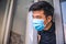 Young asian man with medical mask opens the house door. Coronavirus concept.