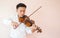 Young Asian man play violin. Classical music instrument. Art and music portrait background with copy space.