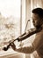 Young Asian man playing violin. Classical music instrument. Sepia color tone.