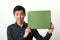 Young Asian man showing green copy space box