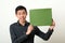 Young Asian man showing green copy space box