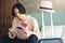 Young Asian man is sitting and checking flight schedules on a smartphone