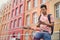 Young Asian man sitting on his bike sending a text