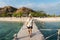 Young Asian man traveller walking on wooden bridge at Kanawa island, Flores island in Komodo national park in Indonesia. Travel