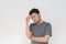 Young Asian man wear grey shirt with thinking and looking idea gesture