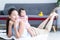Young Asian mother lying on floor, giving cute 7 month newborn baby girl piggyback ride, enjoying active leisure time. Smiling