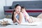 Young Asian mother lying on floor, giving cute 7 month newborn baby girl piggyback ride, enjoying active leisure time. Smiling