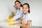 Young asian mother teaching her daughter housekeeping, cleaning kitchen together and smiling at camera