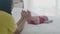 Young asian mother touch foot of little baby girl with tender on bed in the bedroom, mom love newborn and care.