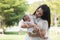 Young Asian mothers or single mom are smiling and carrying newborn babies. Family doing activities and relaxing in the park.