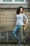 Young asian multicultural woman in leggings and sneakers on the street near the wall, Porto