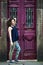 Young asian multicultural woman poses near the old doors on the street of Porto