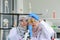Young Asian muslim female scientist wearing safety glasses holding and looking test tube with reagent