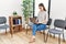 Young asian nurse woman sitting at waiting room using laptop thinking attitude and sober expression looking self confident