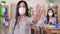 Young asian office worker in a medical protective mask shows a stop gesture