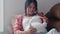 Young Asian Pregnant woman using phone and headphone play music for baby in belly. Mom feeling happy smiling positive and peaceful