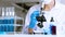 Young Asian scientist Working looking through a  microscope doing research for analyzing a Experiments sample in a forensic