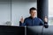 A young Asian sits in a modern office at a computer. Conducts an online meeting via video call