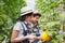 Young asian smart farmers and entrepreneurs in garden, happy and smiling, tablet checking quality, recording science analyzing