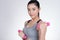 Young asian sporting woman training with dumbbell. Pretty athletic girl making physical exercise against white background. Health