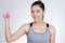 Young asian sporting woman training with dumbbell. Pretty athletic girl making physical exercise against white background. Health