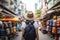 Young Asian traveling backpacker in Khaosan Road outdoor market in Bangkok, Thailand