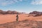 Young Asian traveller with local Arab dress standing on top of mountain and enjoying landscape of Wadi Rum desert, Jordan, Arab