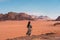 Young Asian traveller with local Arab dress standing on top of mountain and enjoying landscape of Wadi Rum desert, Jordan, Arab