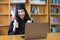 A young Asian university graduate woman in graduation gown expressing joy and excitement to celebrate her education achievement in