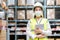 Young asian woman auditor or trainee staff wears mask working during the COVID pandemic in store warehouse shipping industrial.