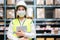 Young asian woman auditor or trainee staff wears mask working during the COVID pandemic in store warehouse shipping industrial.