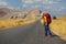 Young asian woman backpacks  as standing near road and hitchhiking. adventure travel, road trip image