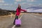 Young asian woman backpacks hold luggage as standing near road and hitchhiking. adventure travel, road trip image