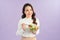 Young asian woman beaming while eating fresh salad