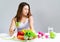 Young Asian woman bored emotion and refuse for eating fresh green vegetables and fruits on table at home, nutrition, weight loss,