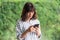 Young Asian woman chatting and searching with smartphone. A happy girl enjoying outdoor lifestyle surrounded by greeny plant.