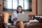 Young asian woman disabled sitting on sofa using laptop computer with prosthetic leg in living room.