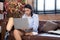 Young asian woman disabled sitting on sofa using laptop computer with prosthetic leg in living room at home, female working on