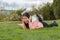 Young Asian woman enjoying novel on grass - lifestyle portrait of young happy and pretty Japanese girl reading a book at beautiful