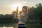 Young Asian woman exercising before a fitness session at the park in front of her house. Young healthy woman warming up