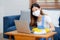 Young asian woman in face mask cleaning and wipe laptop computer with disinfect and alcohol for protect pandemic covid-19.