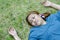 Young Asian woman fainting on grass in park because outdoors of hot weather