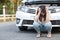 Young asian woman feel sad sitting near the broken down car